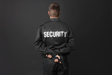 Security guard in uniform with gun on black background, back view