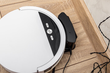 Robot vacuum cleaner is charging at the charging station. Charging dock base. Device for cleaning...