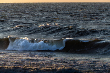 Wind waves in the baltic sea, storm at sea at sunset