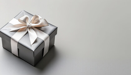 Obraz premium Elegant gift box with satin ribbon stands on a minimalist background, symbolizing luxury, celebration and the joy of a gift