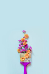 Autumn creative concept of yellow and pink autumn flowers and paint brush.