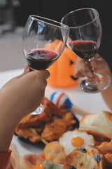 friendship, holiday and people concept - group of happy smiling friends in halloween costumes of vampire, devil, witch and cheetah at home party