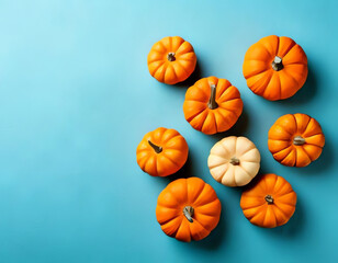 small decorative pumpkins on a light blue background with space for text
