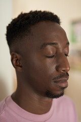 Obraz premium Young African man standing with his eyes closed at home