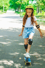 A child girl playing skate or skateboard at parking to wearing safety helmet, elbow and knee...