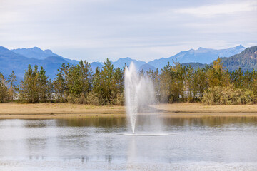 Serene Fountain at Harrison Lake with Mountain Backdrop