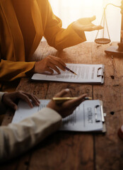 Business and lawyers discussing contract papers with brass scale on desk in office. Law, legal services, advice, justice and law concept picture with film grain effect