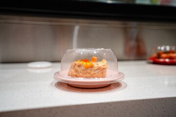various types of sushi on conveyor belt in a Japanese restaurant. Shushi Go Round is a famous form of fast food in Asia, also known as sushi train.