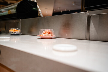 various types of sushi on conveyor belt in a Japanese restaurant. Shushi Go Round is a famous form...