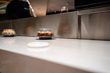 various types of sushi on conveyor belt in a Japanese restaurant. Shushi Go Round is a famous form...