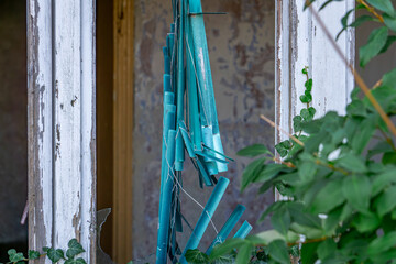broken white window with remains of old window blinds. devastation by man.