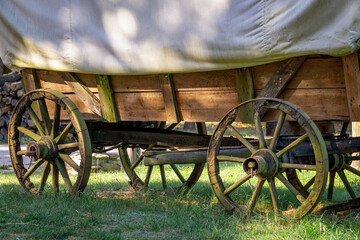 an old horse-drawn cart covered with a white fabric tarp. a horse-drawn wagon from the wild west, like from a western movie.