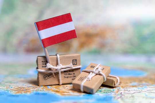 Flag of Austria near the parcels on the world map. World trade. Exports and imports of goods. Economy of the country. - Powered by Adobe
