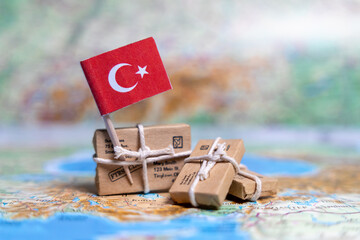 Flag of Turkey near the parcels on the world map. World trade. Exports and imports of goods. Economy of the country.