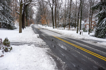 County road covered with slushy snow and ice after the snow storm in February