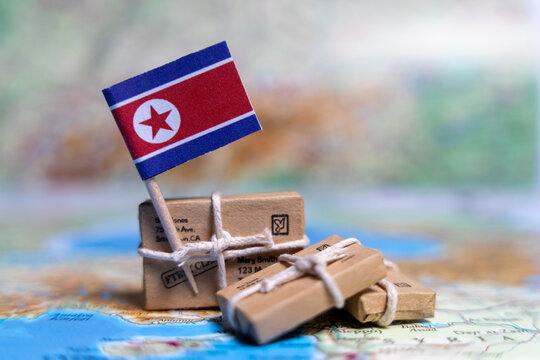 Flag of North Korea near the parcels on the world map. World trade. Exports and imports of goods. Economy of the country