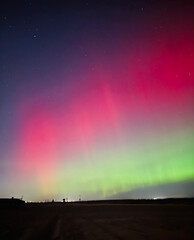Stunning, dreamy display of vivid colors seen from aurora borealis, northern lights over Long Island, NY, 2024.  The G4 geomagnetic storm dazzled over the beach for spectators in awe.  Rare surreal