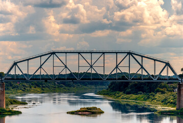 Obraz premium river bridge island green forests clouds day