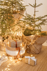 Designer Christmas tree decoration with light decorations. The concept of celebrating New Year and Christmas. Gifts in craft packaging under the Christmas tree