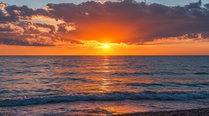 Fototapeta premium Beautiful sunset on the ocean shore with orange and pink clouds.