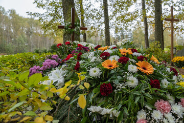 Colorful Flowers in front of a cross in a Cemetery Graveyard