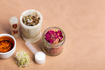 Homeopathy. Homeopathic medicines, small pills, herbs in a glass jar on a kraft background. Alternative medicine.