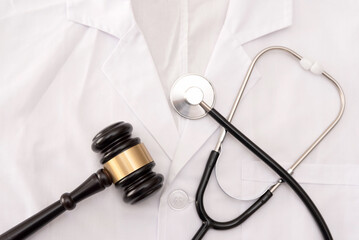 Close up of a Doctor's White Lab Coat with Stethoscope and gavel, medical law or healthcare...