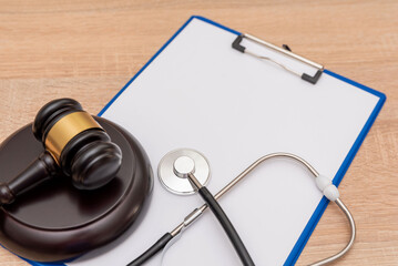 Medical law and justice concept with stethoscope and gavel on clipboard