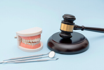 dental model with dentist tools and gavel on neutral background, dental and medical law concept