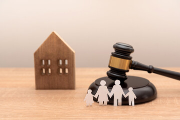 paper family cutout with gavel and wooden house model on wooden desk, Family law and heritage...
