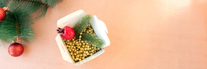 Banner of in white box, instead of Chinese food, there are gold beads, red pomegranate and spruce branches on beige-gold background. holiday or chinese new year concept