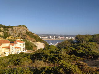 Fototapeta premium Coastal view of a vibrant waterfront town with boats in the harbor on a clear sunny day
