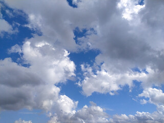 Obraz premium A clear blue sky with fluffy white clouds drifting lazily during a sunny afternoon in a serene outdoor setting