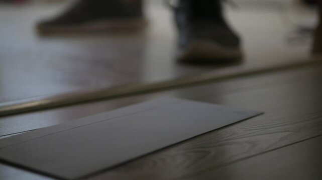 Person Letting a Letter in Front of the Entrance Door for Postman. Man Leaving an Envelope in Front of the Door.