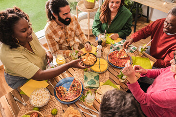 Happy multiethnic family enjoying food together around the table