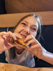 Girl takes a big bite of a burger