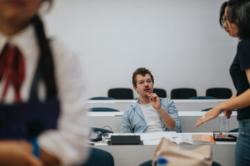 Students engage in thoughtful discussion in a modern university lecture hall. The image captures a...