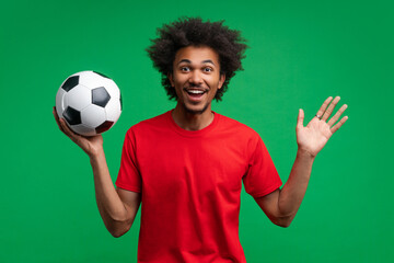Studio portrait of surprised soccer supporter young African American man happy unable to believe he...