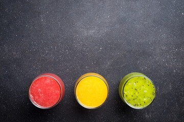 Glasses of fresh juice on gray stone table