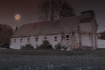 Dark Halloween landscape with abandoned creepy house and moon. Old dilapidated haunted building.