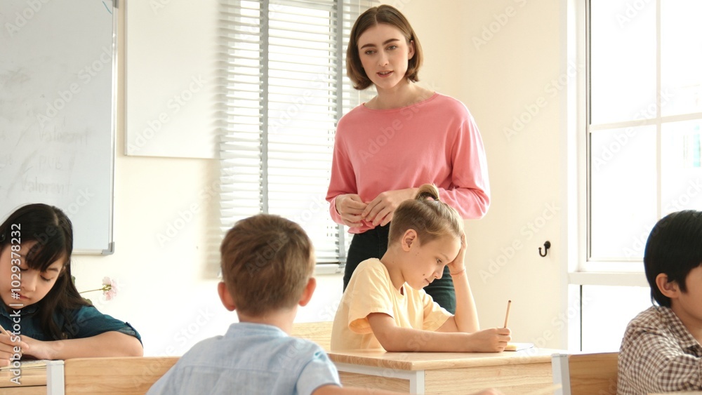 Poster energetic smart teacher explain classwork to caucasian boy at classroom while multicultural student 