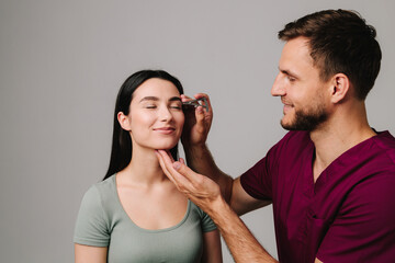 Blepharoplasty marking up. Plastic surgeon is measuring distance in between marking lines for well...