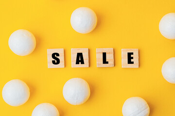Yellow background with white balls and a word Sale written in black letters