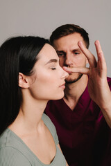 Rhinoplasty. Woman is going through nose surgery to constantly remove dorsal hump. Rhinoplasty to improve appearance of nose.