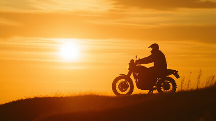 A motorcycle framed against a setting sun with a silhouette of the rider as they pause on a quiet hilltop.