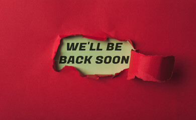 A red background with a yellow sign that says We'll be back soon