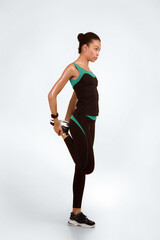 Sporty Black Woman Stretching Leg Warming Up Before Workout Standing Over Yellow Studio Background. Full Length