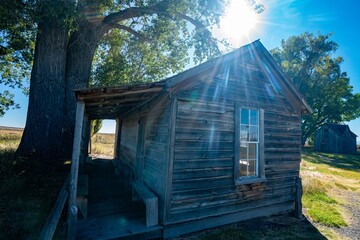 Vintage abandoned homestead house with sunburst over head near Frenchglen Oregon