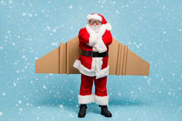 Full length body size view of his he nice fat dissatisfied moody sullen St Nicholas Santa wearing warm coat plane wings folded arms isolated over blue pastel color background
