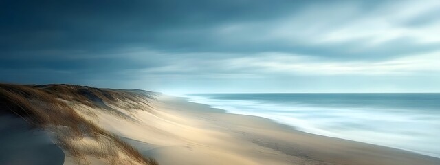 A long exposure photograph of the beach. The ocean is calm and blue, with some fog on top